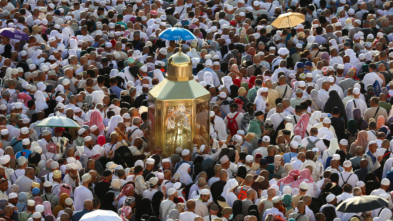 Muslim worshippers make their way towards the Kaaba, Islam's holiest shrine, at the Grand Mosque complex in in the holy city of Mecca to take part in morning prayers on the first day of Eid Al-Adha, the feast of the sacrifice, early on June 6, 2025.