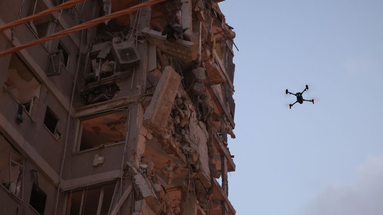 A drone flies beside a damaged building following a strike by an Iranian missile in the Israeli city of Bat Yam, south of Tel Aviv, early on June 15, 2025.