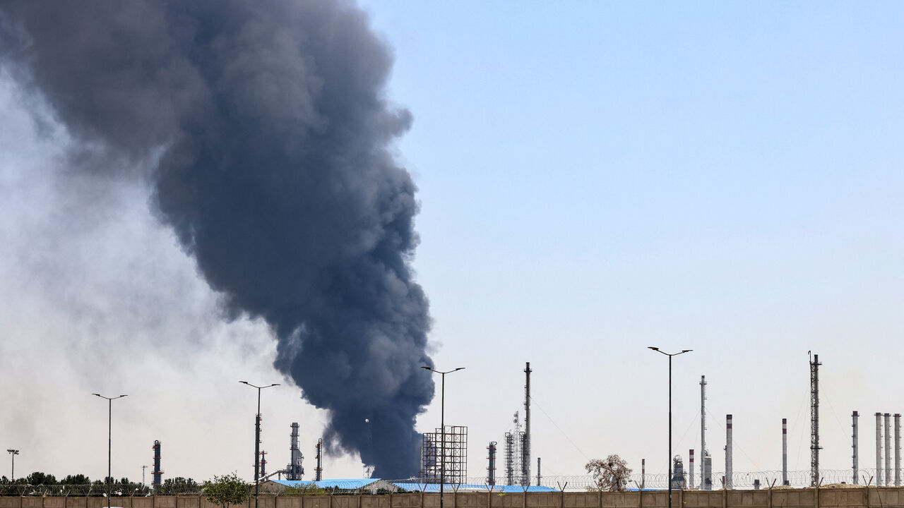 A plume of heavy smoke and fire rise over an oil refinery in southern Tehran, after it was hit in an overnight Israeli strike, on June 15, 2025.