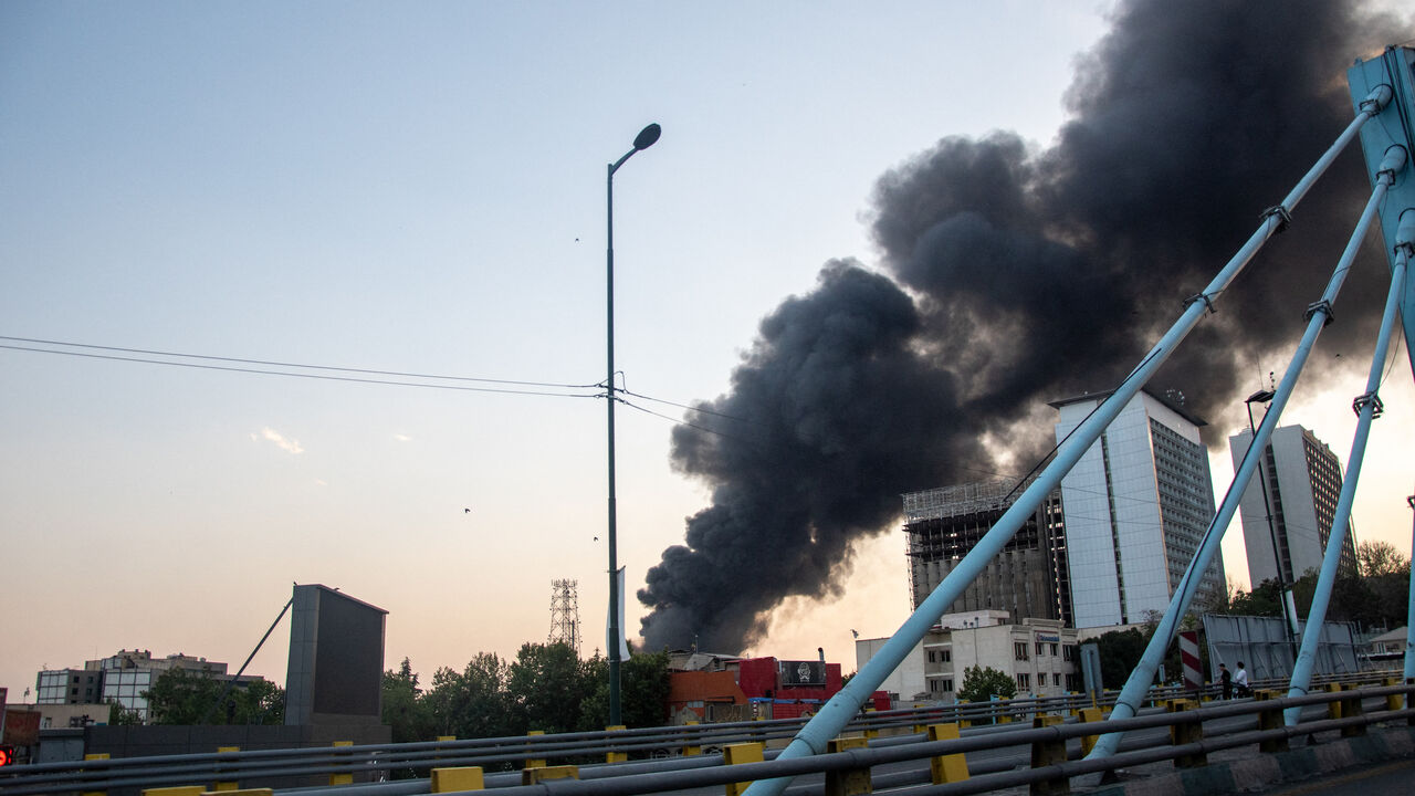 Smoke rises from the rubble of an Iranian state media building in Tehran after an Israeli airstrike on June 16, 2025.