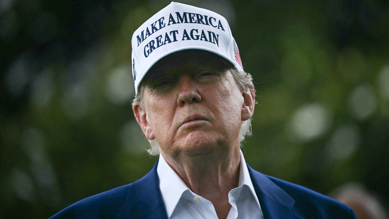 US President Donald Trump speaks to the press as workers install a large flag pole on the South Lawn of the White House in Washington, DC on June 18, 2025.