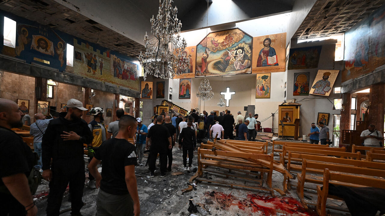 People and rescuers inspect the damage at the site of a reported suicide attack at the Saint Elias church in Damascus' Dweila area on June 22, 2025.