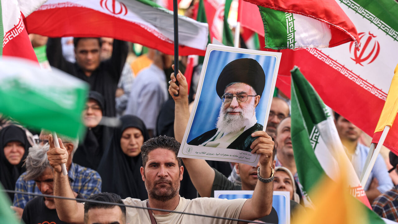 An Iranian man holds a portrait of supreme leader Ayatollah Ali Khamenei as people celebrate a ceasefire between Iran and Israel at Enghlab Square in the capital Tehran on June 24, 2025.