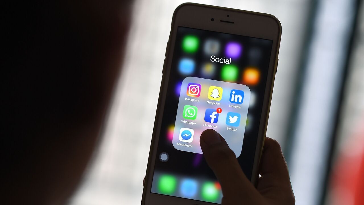 This photo taken on March 22, 2018, shows a woman looking at social networking applications on a smartphone in Kuala Lumpur.