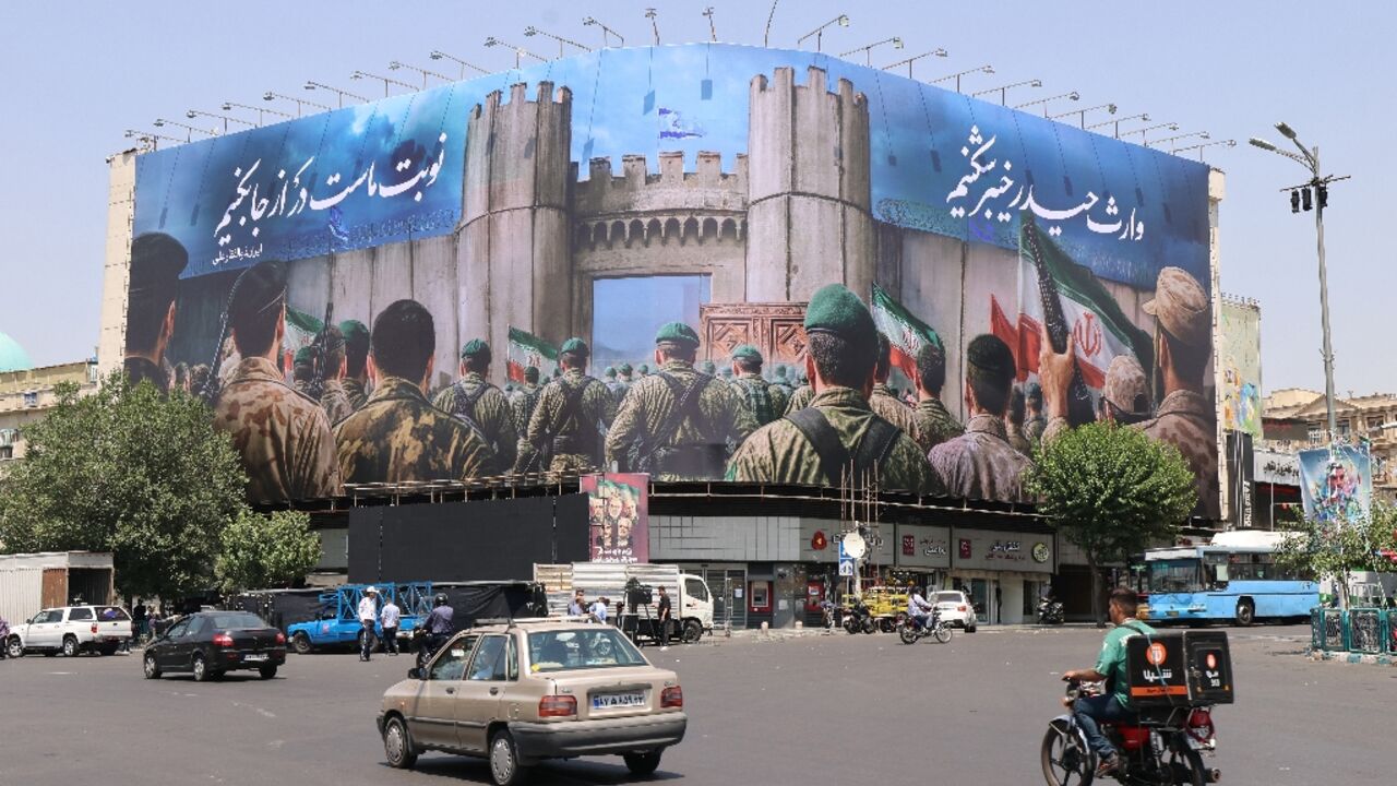 Iranians drive past an anti-Israel poster in Tehran's Enghlab Square Iranians drive past an anti-Israel poster in Tehran's Enghlab Square