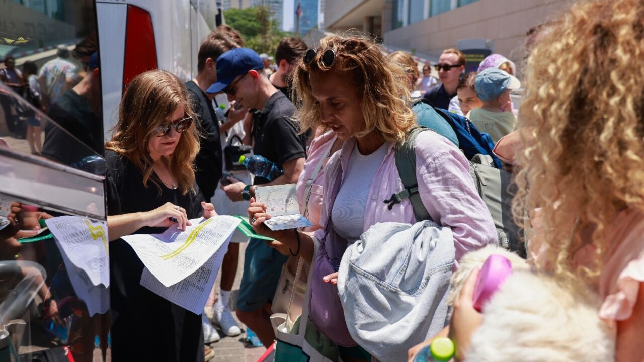 People register before the departure of a bus slated to evacuate foreign passport holders, mainly European and Polish, out of Israel, at a meeting point in Tel Aviv People register before the departure of a bus slated to evacuate foreign passport holders, mainly European and Polish, out of Israel, at a meeting point in Tel Aviv
