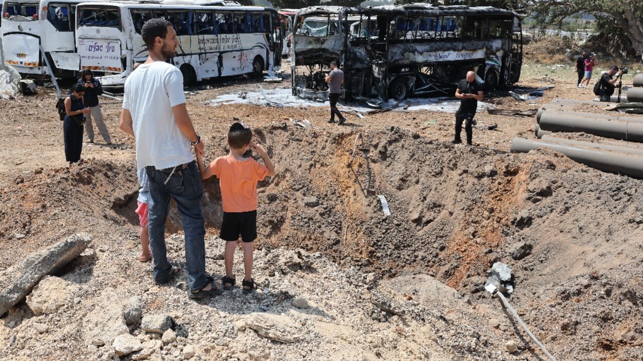 Israelis inspect the impact crater of a Iranian missile which struck a bus depot in Herzliya near Tel Aviv.