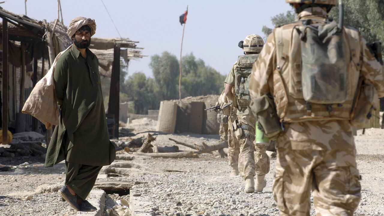 FILE PHOTO: British Army soldiers patrol through a market street in southern Helmand province, Afghanistan, November 7, 2007. REUTERS/Steve Lewis/File Photo