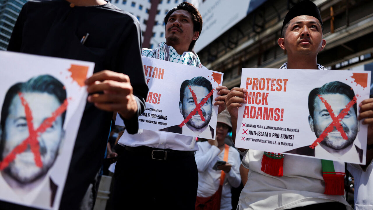 Protesters hold pictures of Nick Adams as they protest U.S. President Donald Trump's nomination of Nick as the U.S. ambassador to Malaysia, outside the U.S. Embassy in Kuala Lumpur, Malaysia July 18, 2025. REUTERS/Hasnoor Hussain