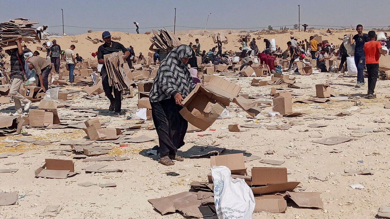 FILE PHOTO: Palestinians gather to collect what remains of relief supplies from the distribution center of the U.S.-backed Gaza Humanitarian Foundation, in Rafah, in the southern Gaza Strip, June 5, 2025. REUTERS/Stringer/File Photo