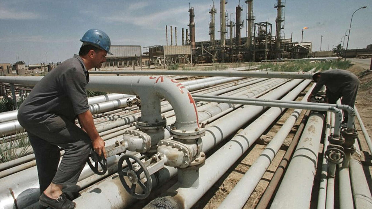 Iraqi workers tend to a pipe at the Iraqi-Turkish pipeline in Karkuk, northern Iraq, Dec. 1, 2000.
