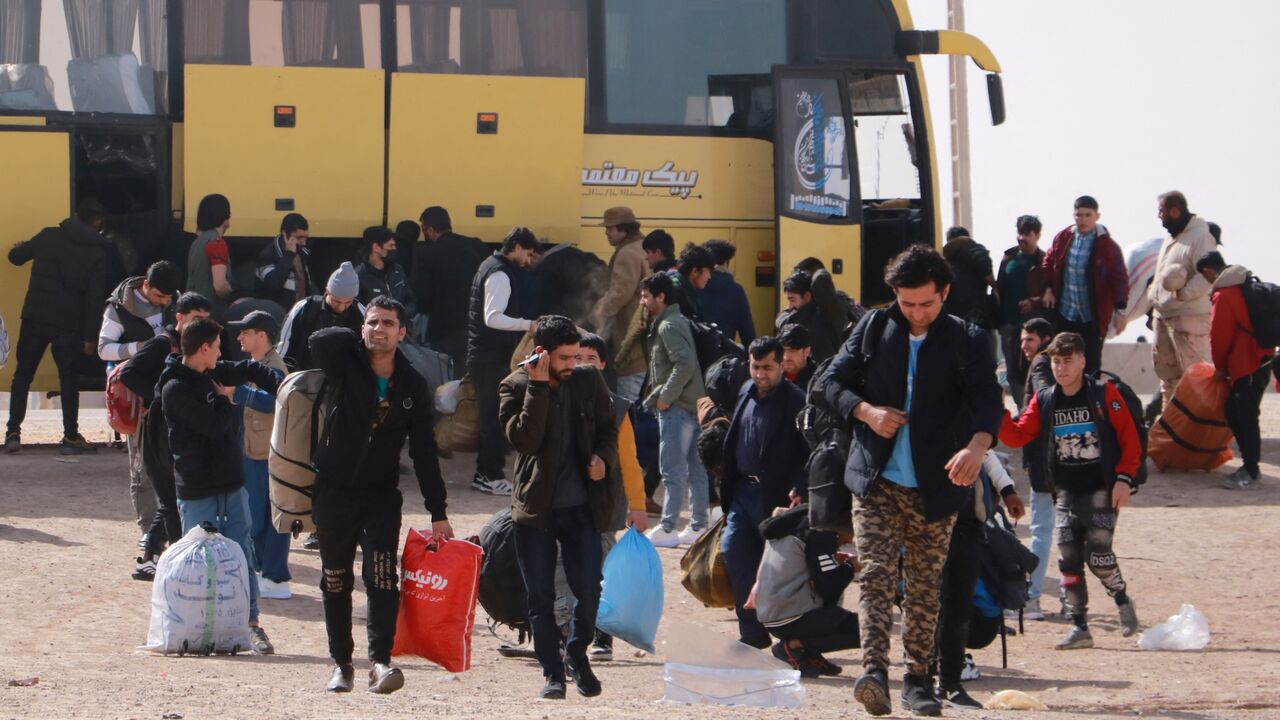 Afghan migrants who were living in Iran as refugees deboard a bus after being deported back to Afghanistan at the zero point between Afghanistan and Iran in the Herat province on Feb. 23, 2025.