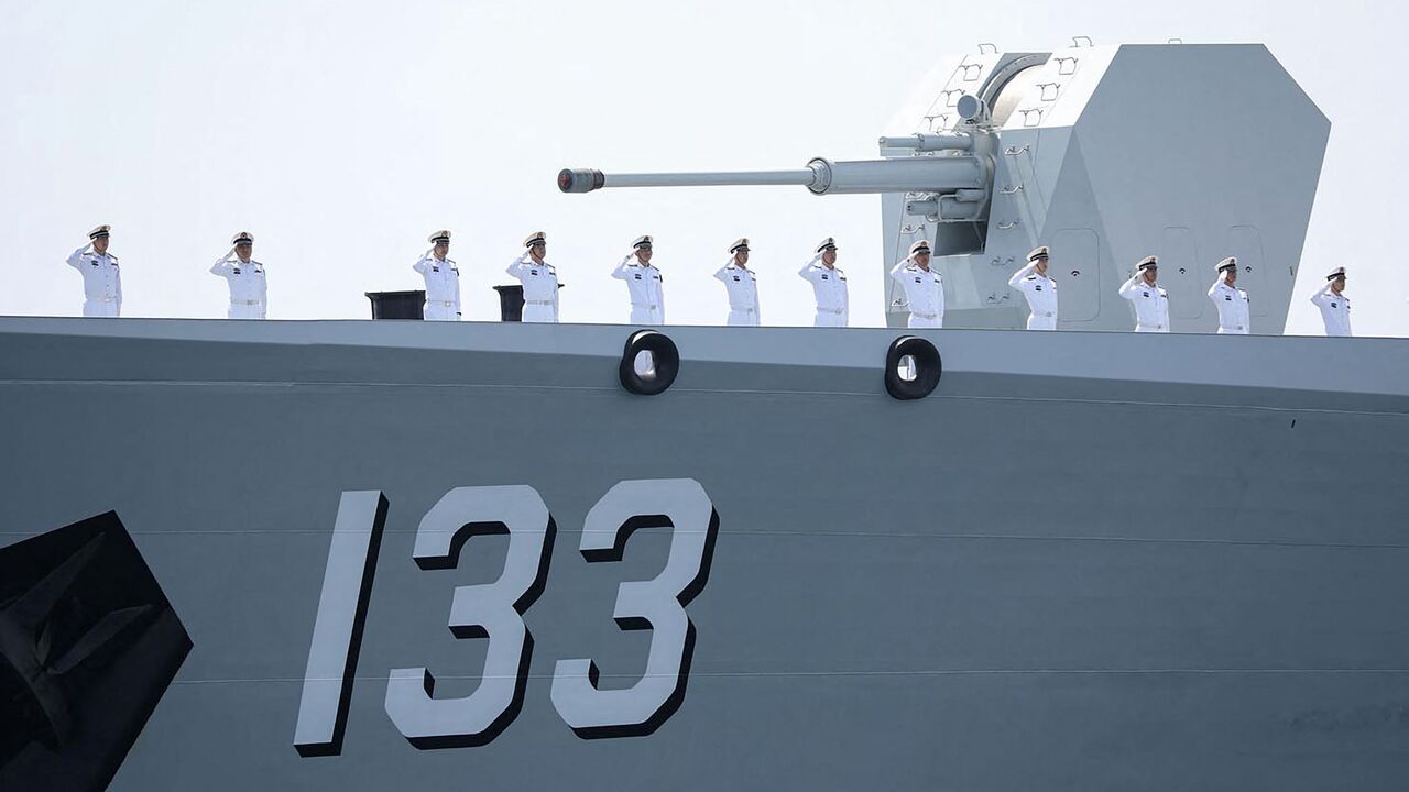 This handout photo made available by the Iranian Army Office on March 12, 2025, shows navy personnel saluting aboard a Chinese military ship during a joint Iranian-Russian-Chinese drill in the Gulf of Oman.