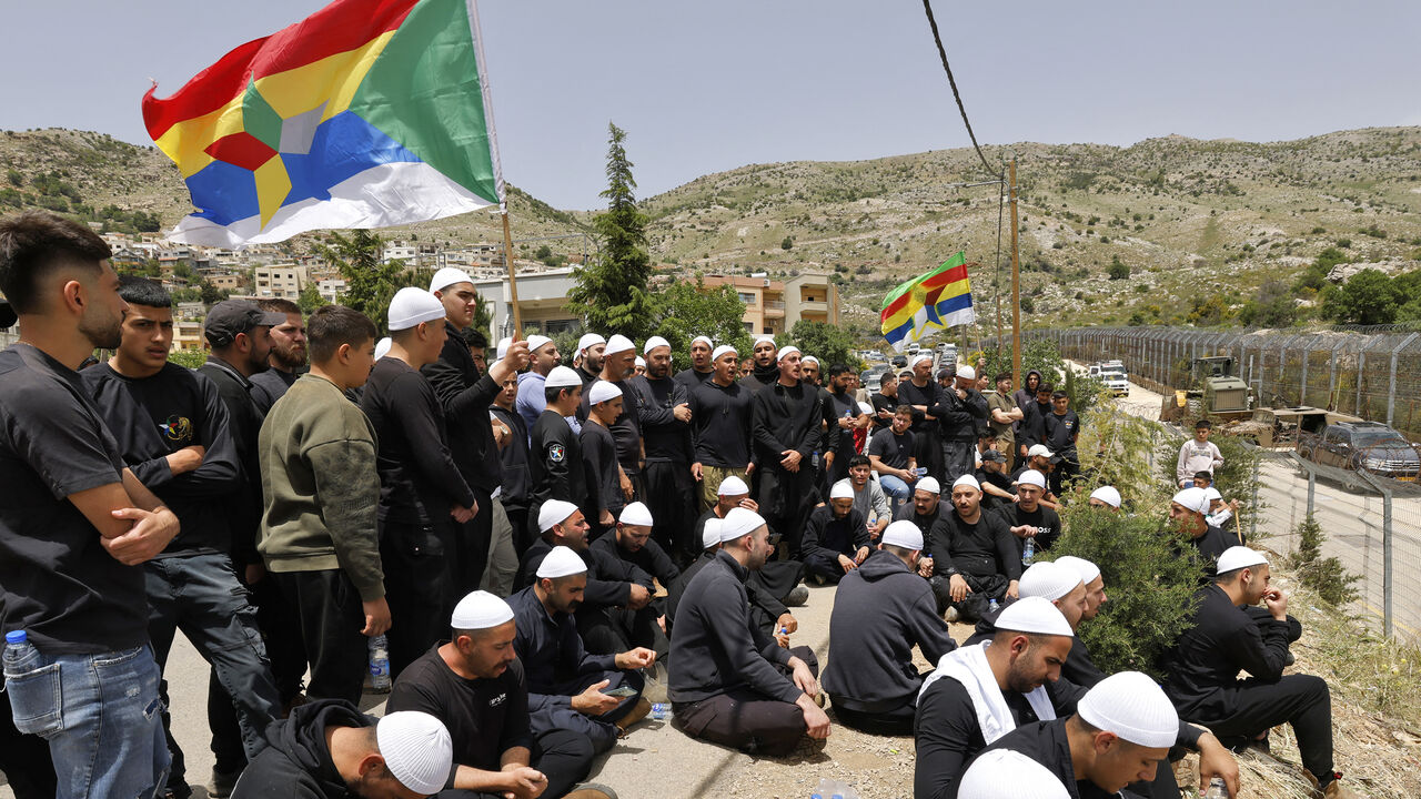 Druze men demonstrate in solidarity with the Syrian Druze community near the border barrier in the village of Majdal Shams, Israeli-annexed Golan Heights, April 30, 2025.