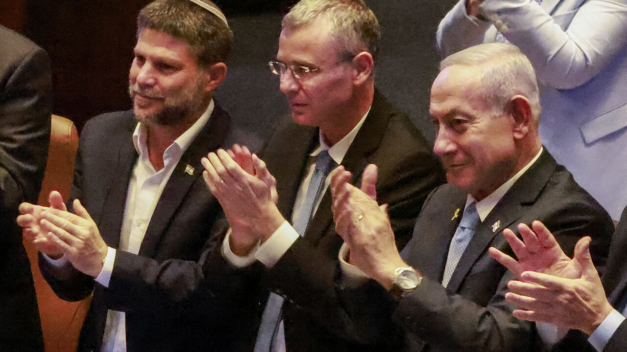 Israel's (L to R) Finance Minister Bezalel Smotrich, Justice Minister Yariv Levin, and Prime Minister Benjamin Netanyahu applaud during the address of Argentina's President to a session of the Israeli parliament (Knesset) at its headquarters in Jerusalem on June 11, 2025. (Photo by Menahem KAHANA / AFP) (Photo by MENAHEM KAHANA/AFP via Getty Images)