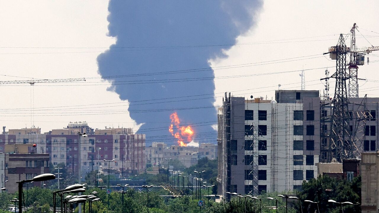 A plume of heavy smoke and fire rise from an oil refinery in southern Tehran after it was hit in an overnight Israeli strike, on June 15, 2025.