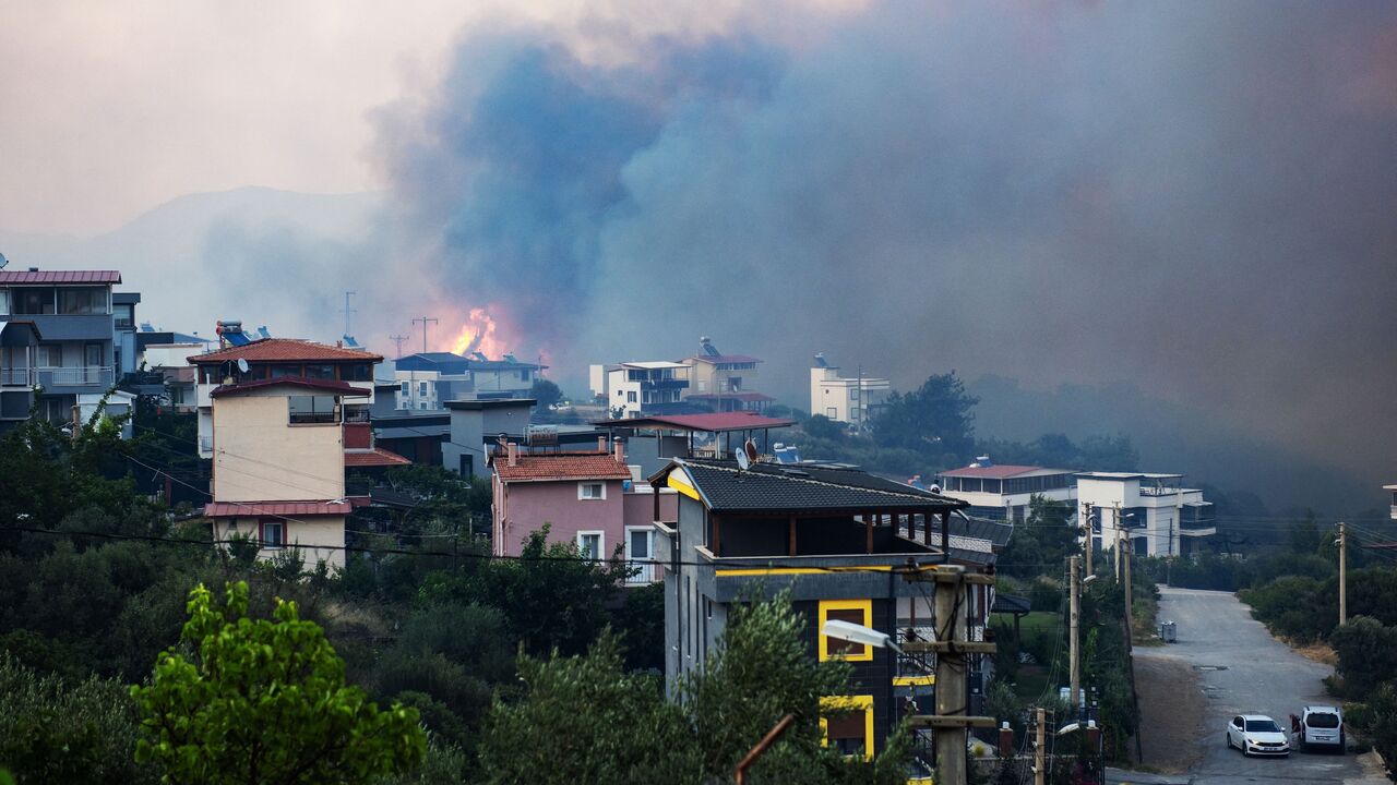 Smoke and flames rise from a forested area following a wildfire in the Seferihisar district of Izmir, Turkey, June 30, 2025.