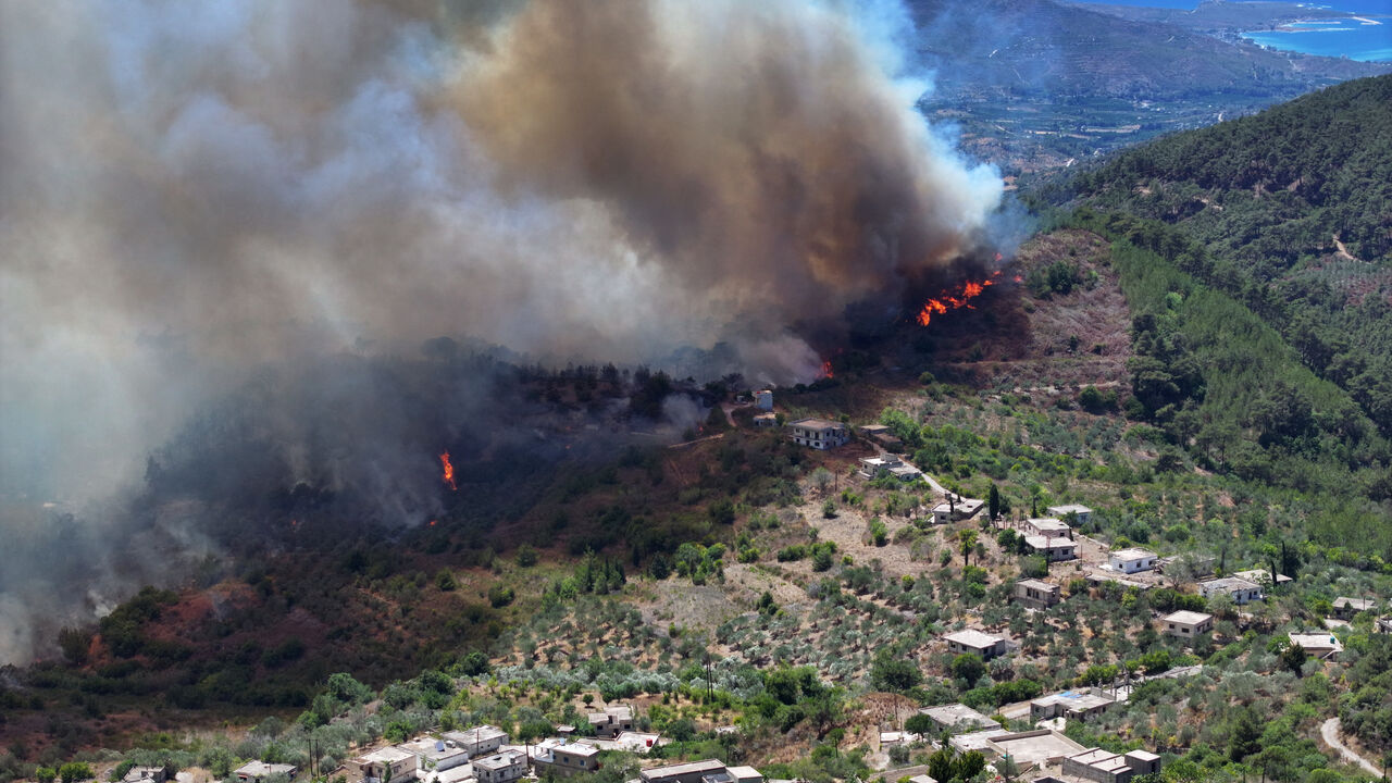 An aerial view shows smoke billowing from a forest fire in the coastal Syrian province of Latakia on July 5, 2025. Syrian emergency workers were battling forest fires raging in the coastal province of Latakia on Saturday for a third day in tough conditions as neighbouring Turkey sent assistance. Syria's ministry for emergencies and disaster management said teams from Turkey began helping on Saturday morning "as part of regional coordination to face the fires", with the assistance including two aircrafts and