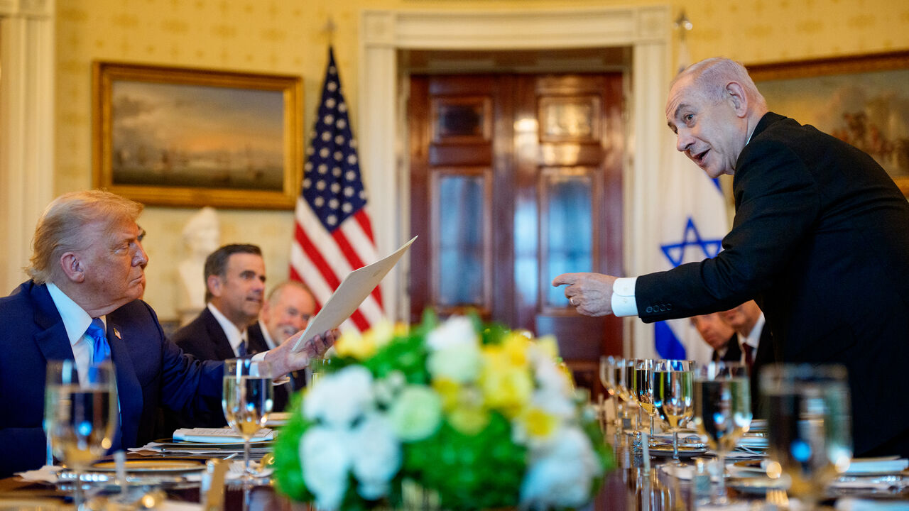 Israeli Prime Minister Benjamin Netanyahu (R) holds the letter he sent to the Nobel Peace Prize committee to nominate US President Donald Trump (L) for the Nobel Peace Prize during a dinner in the Blue Room of the White House, Washington, July 7, 2025.