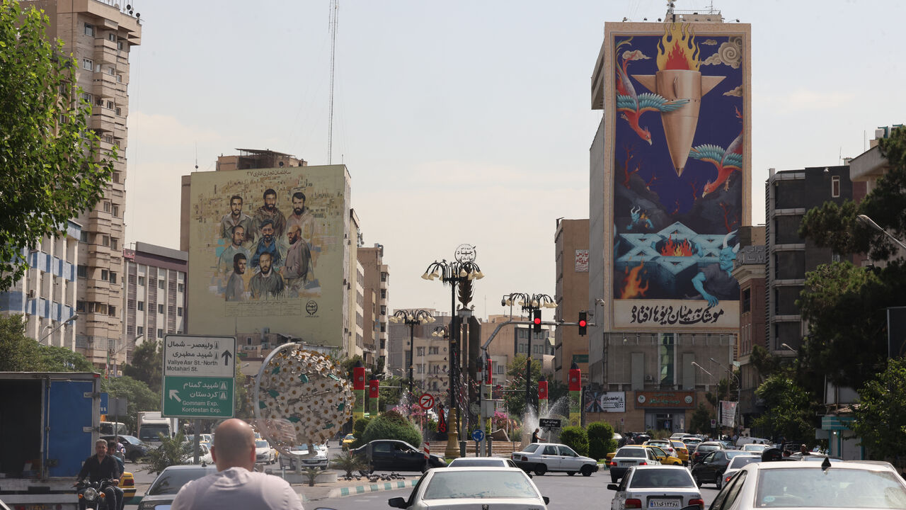 Traffic flows past a huge billboard bearing a painting of a missile falling on Israel with the slogan in Farsi: "The missile has fallen amidst the demons", on a main road in central Tehran on July 16, 2025. A 12-day war between Iran and Israel last month was sparked by an Israeli bombing campaign that hit military and nuclear sites as well as residential areas in Iran. (Photo by ATTA KENARE / AFP) (Photo by ATTA KENARE/AFP via Getty Images)
