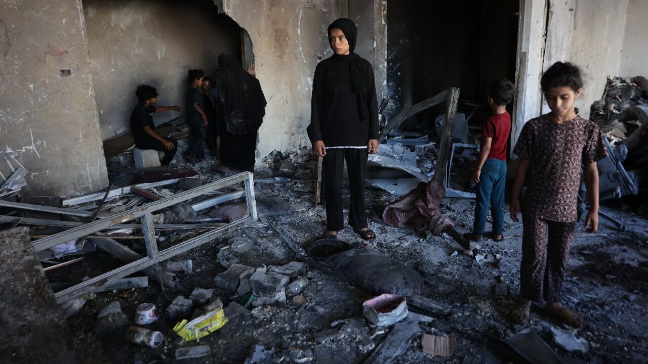 People inspect the damage after a reported Israeli strike on a clinic-turned-shelter in the Al-Rimal neighborhood of Gaza City People inspect the damage after a reported Israeli strike on a clinic-turned-shelter in the Al-Rimal neighborhood of Gaza City