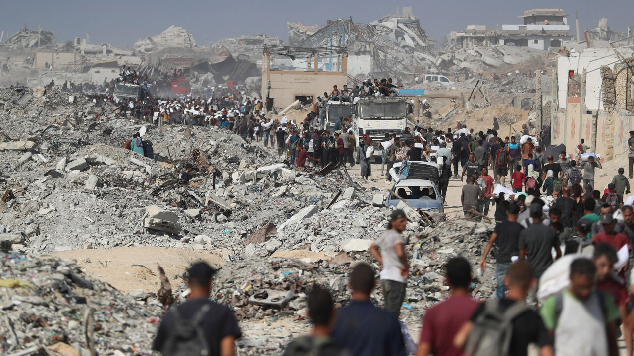 FILE PHOTO: Palestinians carry aid supplies that entered Gaza through Israel, in Beit Lahia, northern Gaza Strip, August 2, 2025. REUTERS/Mahmoud Issa/File Photo