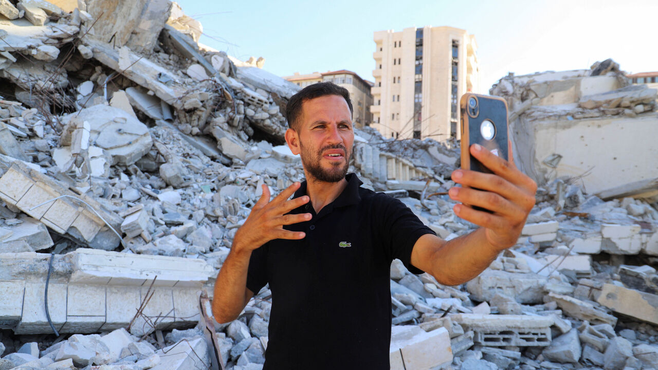 Hearing-impaired Palestinian influencer Basem Al-Habel, who turned to social media to document the war in Gaza through sign language, reaching a wide range of followers from both inside and outside of the enclave, films himself in Gaza City, August 5, 2025.REUTERS/Ebrahim Hajjaj