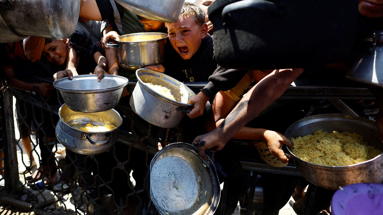 Palestinians wait to receive food from a charity kitchen after the global hunger monitor, Integrated Food Security Phase Classification (IPC), said that Gaza City and surrounding areas are officially suffering from famine that will likely spread, in Gaza City, August 28, 2025. REUTERS/Mahmoud Issa
