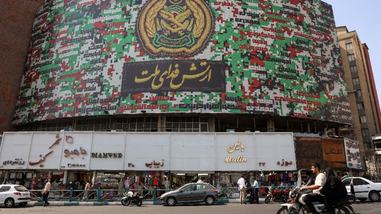 Iranians drive past a billboard with the colors of Iran's national flag Iranians drive past a billboard with the colors of Iran's national flag