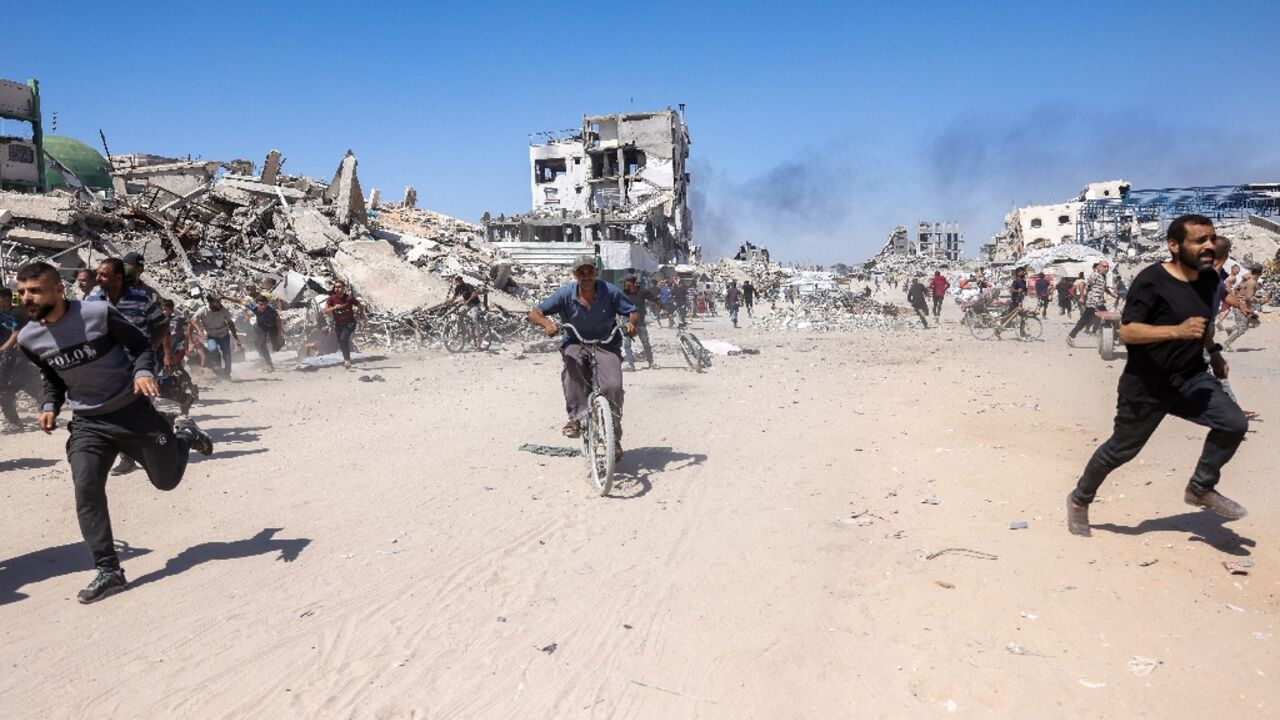 Palestinians run for cover during an Israeli drone strike in northern Gaza on May 23, 2025