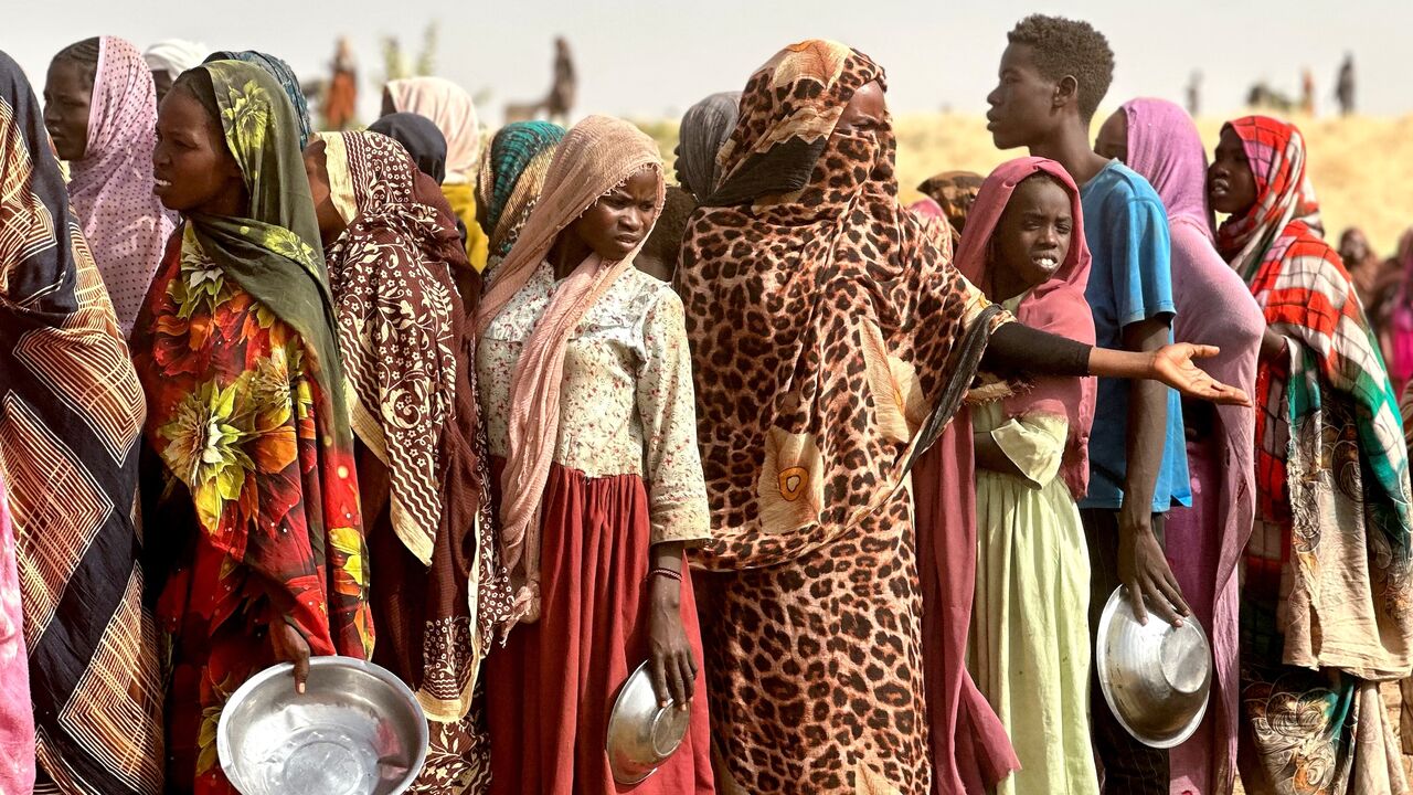 People who fled the Zamzam camp for the internally displaced after it fell under RSF control queue for food rations in a makeshift encampment in an open field near the town of Tawila in Sudan's western Darfur region on April 13, 2025.