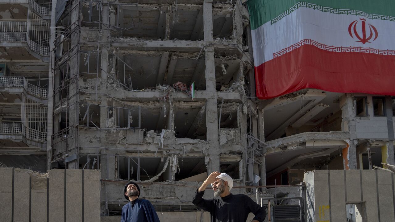 Two men look at houses destroyed in Israeli attacks, July 12, 2025, Tehran.