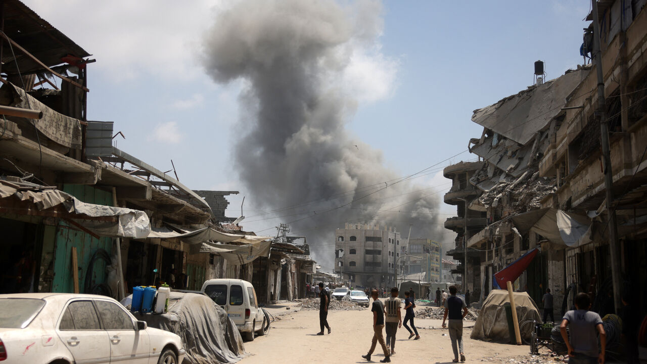 Palestinians watch as a plume of smoke rises during an Israeli strike on Gaza City's southern al-Zeitoun neighbourhood on Aug. 8, 2025.