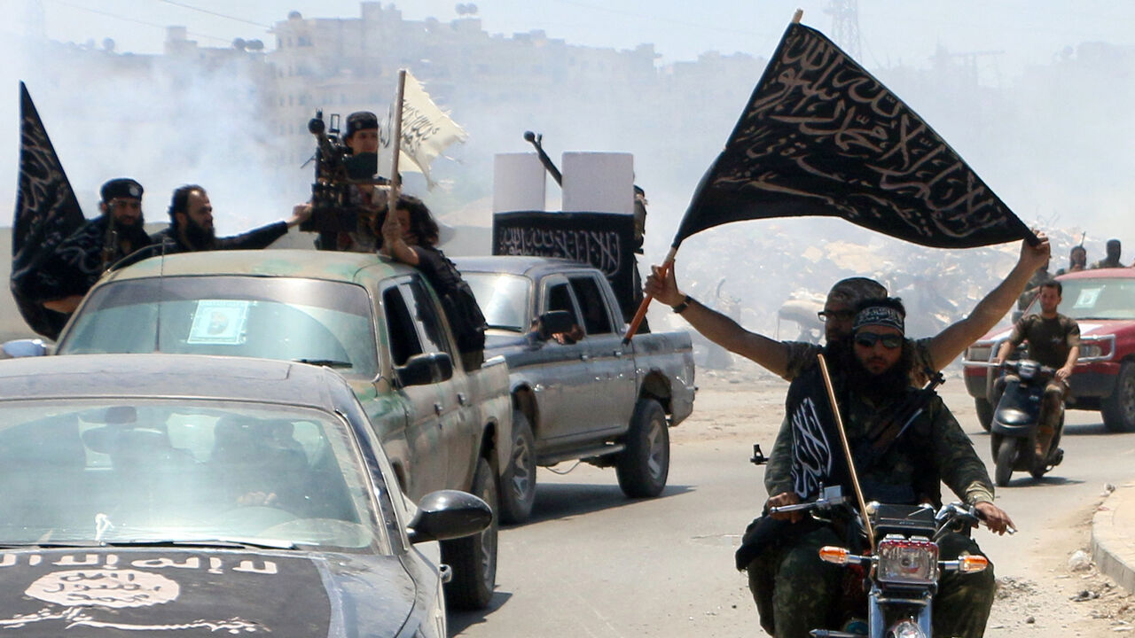 Fighters from Al-Qaeda's Syrian affiliate Al-Nusra Front drive in the northern Syrian city of Aleppo flying Islamist flags as they head to a frontline, on May 26, 2015.