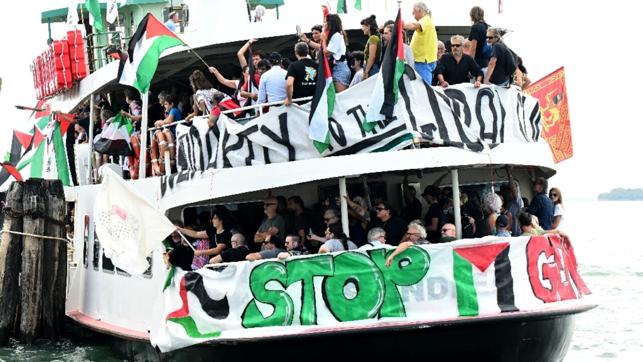People aboard a boat wave Palestinian flags as they arrive to take part in a demonstration in support of Gaza at the Venice Lido People aboard a boat wave Palestinian flags as they arrive to take part in a demonstration in support of Gaza at the Venice Lido