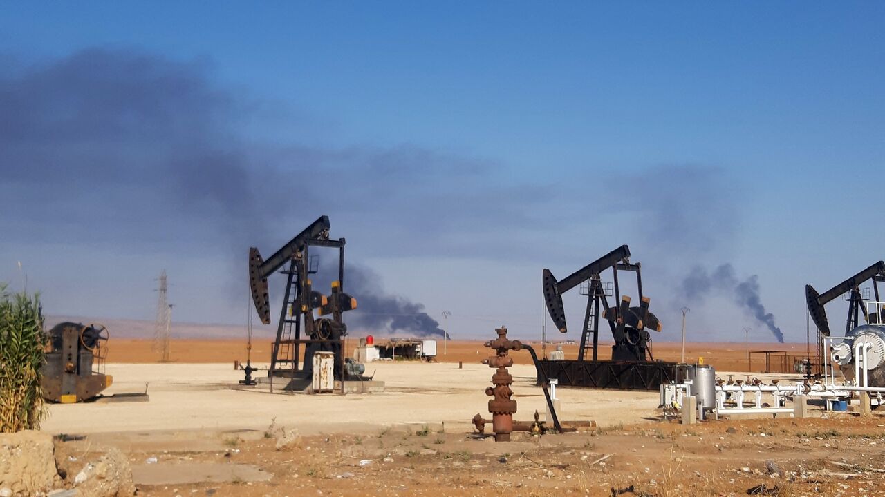 This picture shows pumpjacks in an oil field and smoke plumes rising in the background, following reported Turkish drone strikes near the town of al-Qahtaniyah in Syria's northeastern Hasakah province, close to the border with Turkey, on Nov. 23, 2022.