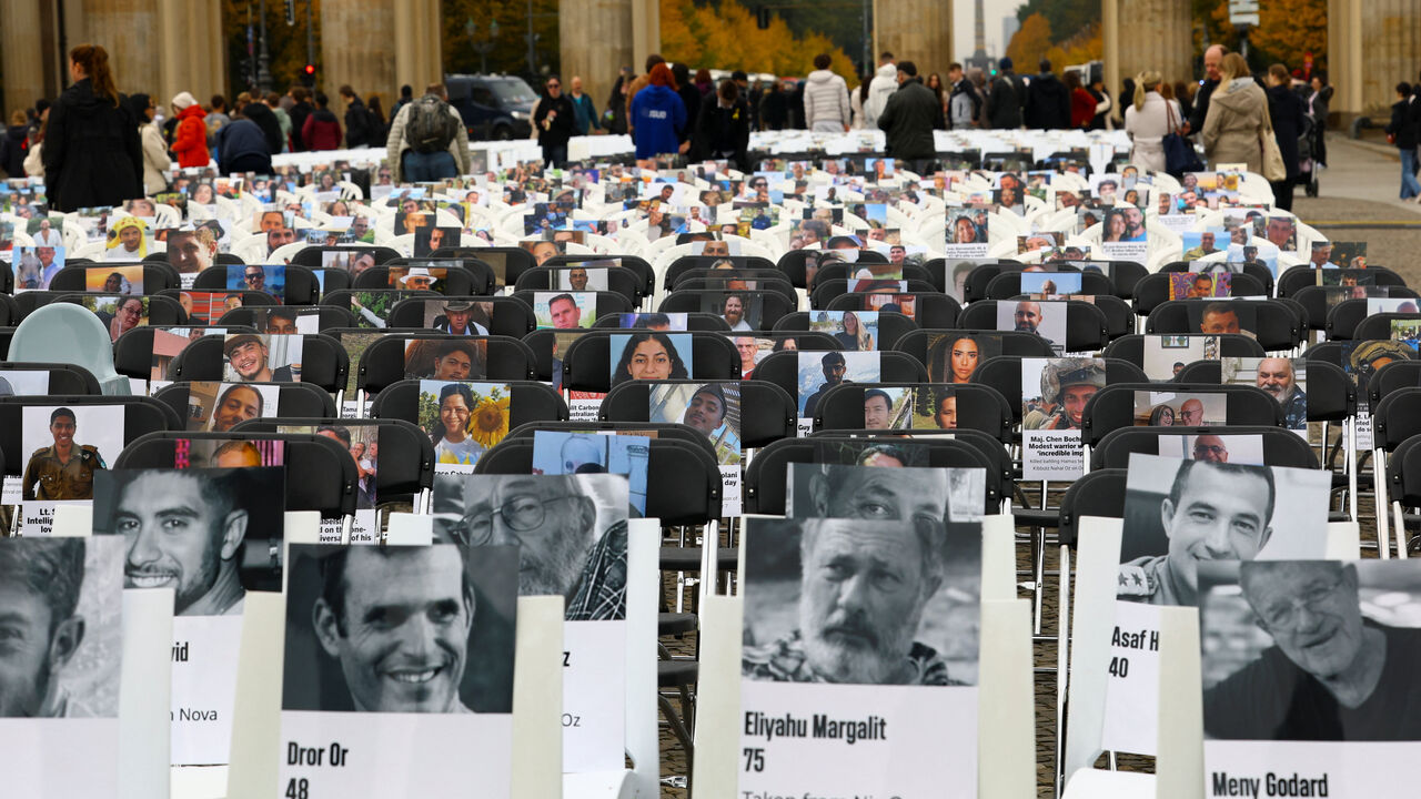 Pictures of victims are placed on chairs as people attend a vigil to mark the two-year anniversary of the deadly October 7, 2023 attack on Israel by Hamas from Gaza, at the Brandenburg Gate in Berlin, Germany, October 7, 2025. REUTERS/Lisi Niesner