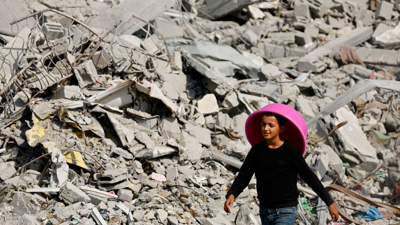 FILE PHOTO: A Palestinian youth walks past the rubble of destroyed buildings, amid a ceasefire between Israel and Hamas, in Gaza City, November 2, 2025. REUTERS/Mahmoud Issa/File Photo