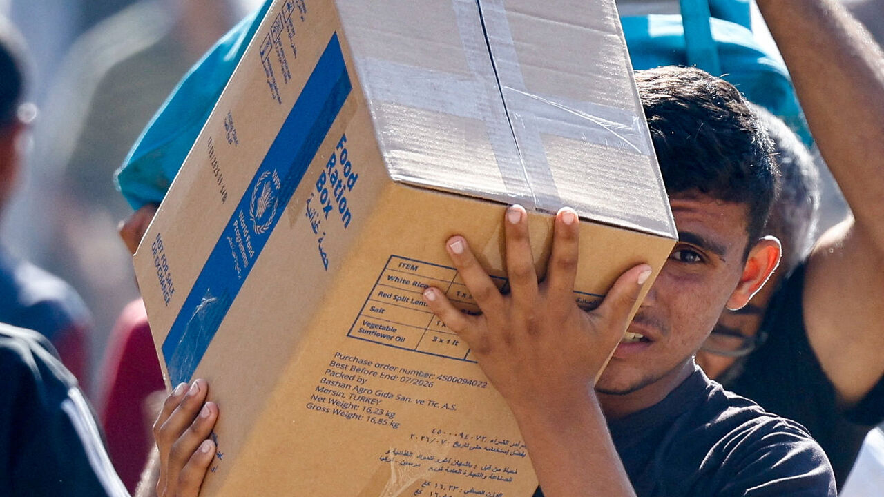 A Palestinian carries aid supplies that entered Gaza, amid a ceasefire between Israel and Hamas in Gaza, in Zawaida in the central Gaza Strip. REUTERS/Mahmoud Issa