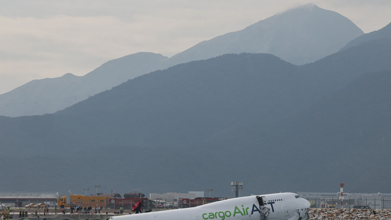 A cargo plane lies partially in the sea after veering off the runway during landing at Hong Kong International Airport in Hong Kong, China, October 20, 2025. REUTERS/Tyrone Siu