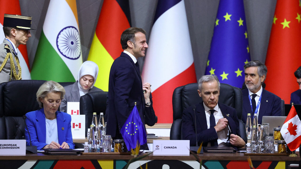 France's President Emmanuel Macron walks past European Commission President Ursula von der Leyen and Canada's Prime Minister Mark Carney during a plenary session on the first day of the G20 Leaders' Summit at the Nasrec Expo Centre in Johannesburg, South Africa, November 22, 2025. REUTERS/Yves Herman