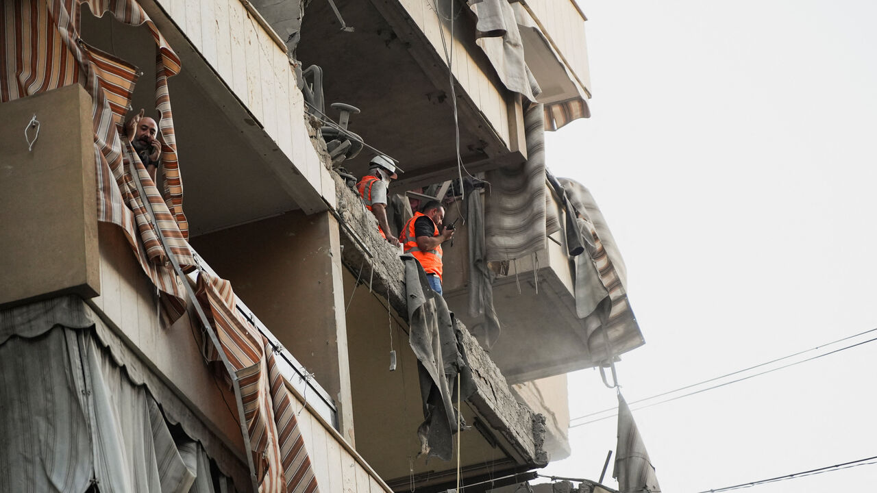 People inspect a damaged building, after Israeli military said on Sunday that it struck a militant from the Lebanese Iran-aligned Hezbollah group, in Beirut's southern suburbs, Lebanon November 23, 2025. REUTERS/Mohammed Yassin