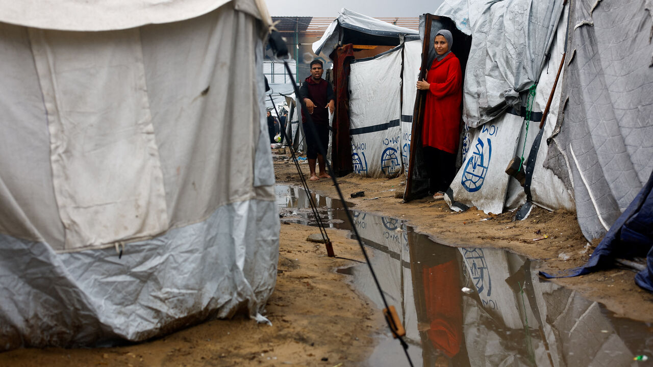 Displaced Palestinians shelter at a flooded tent camp, during a rainy day in Gaza City, November 25, 2025. REUTERS/Mahmoud Issa