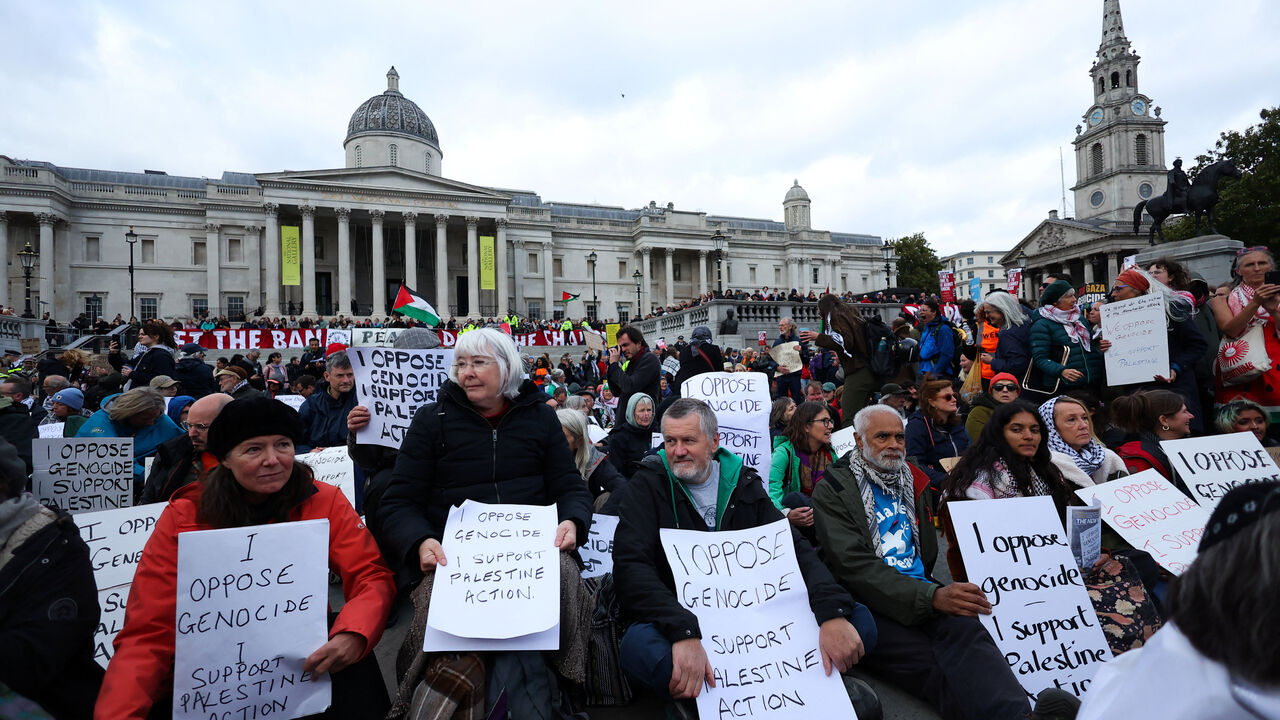 Protesters hold placards during a mass demonstration organised by Defend our Juries, against the British government's ban on Palestine Action, at Trafalgar Square in London, Britain, October 4, 2025. REUTERS/Toby Melville
