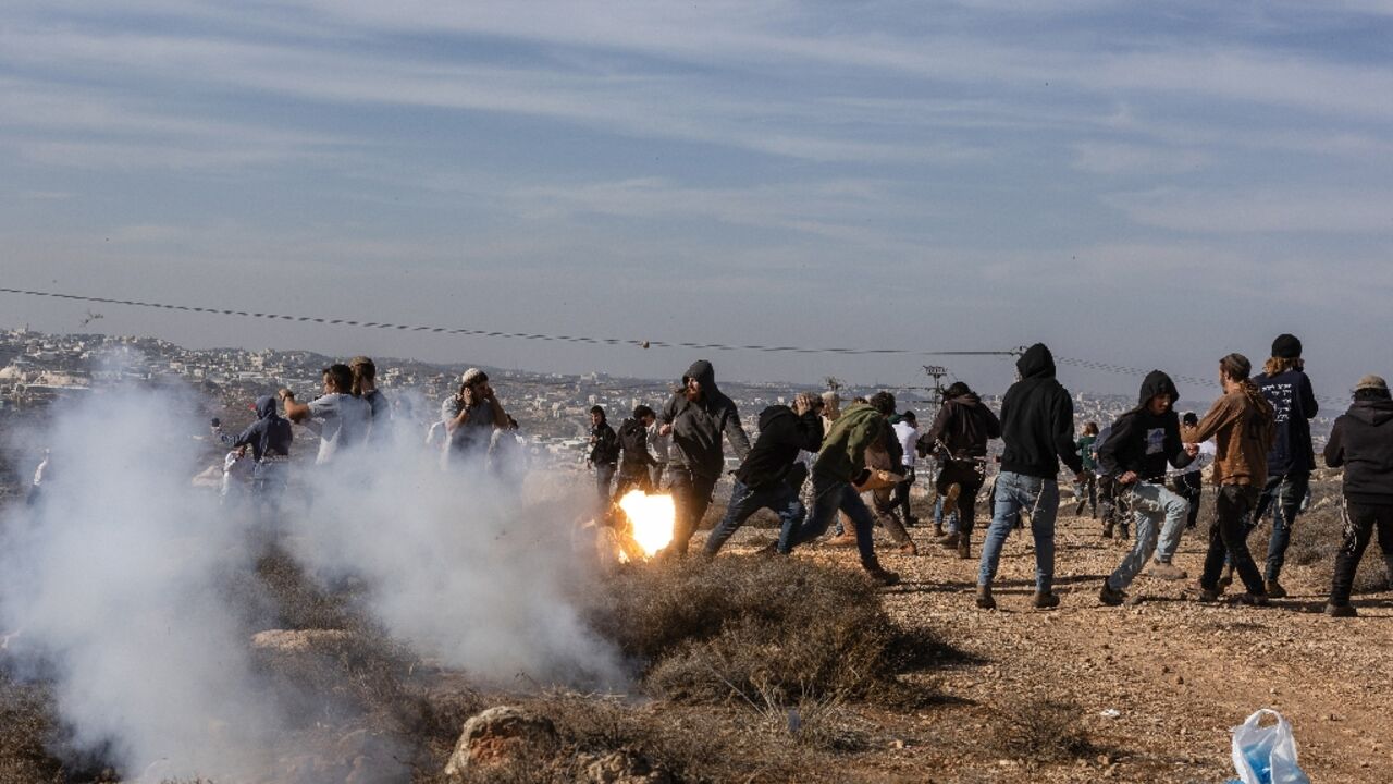 Hilltop Youth members run for cover as they clash with Israeli security forces evacuating and demolishing the illegal outpost