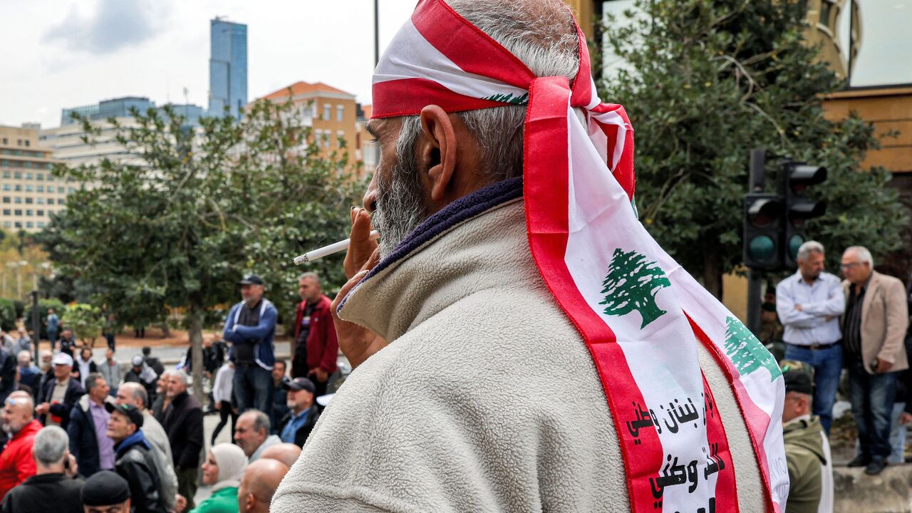 A demonstrator wearing a bandana in the colours of the Lebanese flag smokes a cigarette as retired Lebanese army and security forces veterans gather to protest outside the government palace headquarters in the centre of Beirut on March 22, 2023, demanding inflation-adjustments to their pensions. (Photo by Joseph EID / AFP) (Photo by JOSEPH EID/AFP via Getty Images)