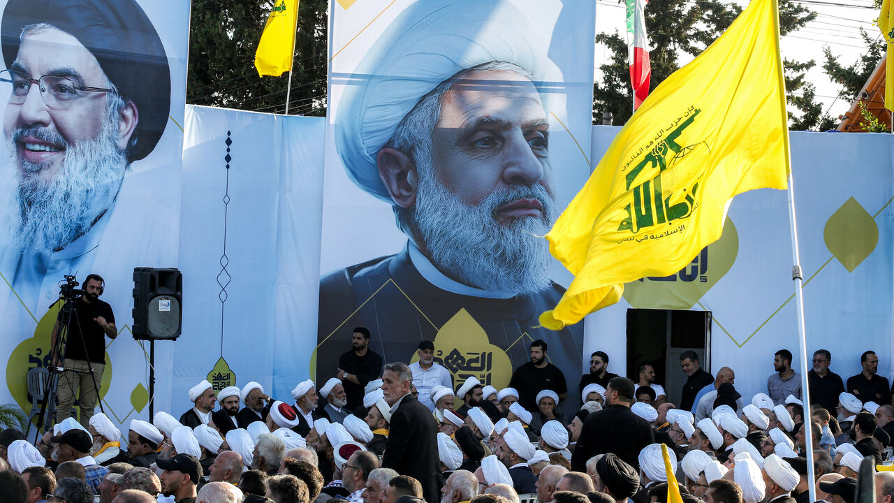 A large picture of Naim Qassem (C), current leader of the Lebanese Shiite movement Hezbollah, is displayed near another of the group's slain longtime leader Hassan Nasrallah during a ceremony marking the first anniversary of Israel's assassination of Nasrallah and other group leaders, in the town of Deir Qanoun al-Nahr near Tyre in southern Lebanon on September 27, 2025. The Iran-backed group, weakened by a deadly war with Israel last year, has organised a series of commemorative events to mark Nasrallah's 