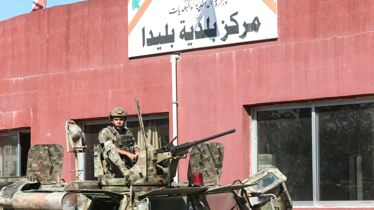 EDITORS NOTE: Graphic content / A Lebanese soldier sits on top of a military vehicle outside the municipality building of the southern Lebanese border village of Blida in the aftermath of an Israeli army raid on the village, on October 30, 2025. The Israeli military on October 30 killed a municipal worker in a raid in southern Lebanon, prompting the Lebanese president to order the army to confront such incursions. Israel's military confirmed the raid, saying it was operating against Hezbollah infrastructure