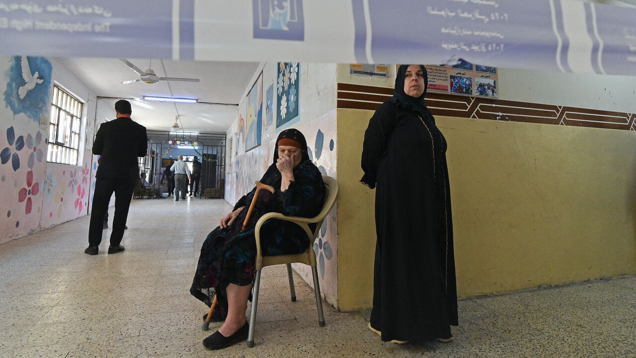 Iraqi voters wait to cast their ballots at the Al-Ghufran school, turned into a polling station in the northern Iraqi city of Mosul on Nov. 11, 2025 during Iraq's parliamentary elections. 