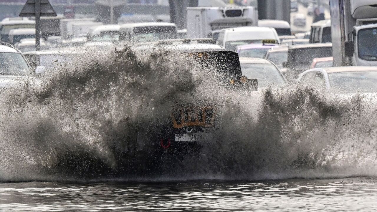 Vehicles negotiate a flooded road in Dubai on December 18, 2025